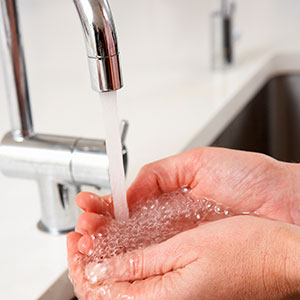Tap flowing water into hands